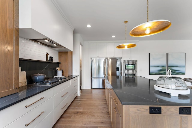 kitchen with a kitchen island, premium range hood, dark wood-style floors, white cabinets, and appliances with stainless steel finishes