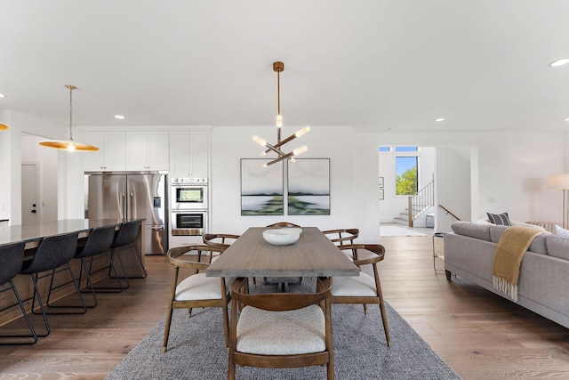 dining room featuring recessed lighting, a chandelier, wood finished floors, and stairway