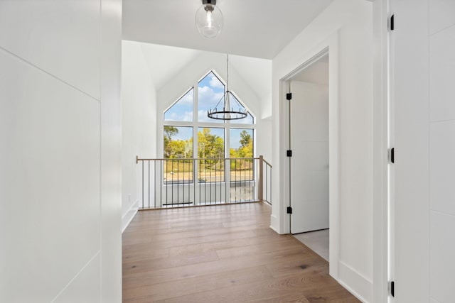 interior space with baseboards, vaulted ceiling, and wood finished floors