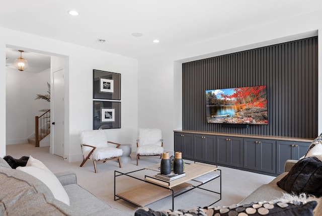 living room with stairs, recessed lighting, baseboards, and light colored carpet