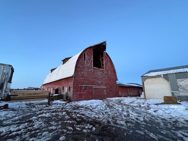 exterior space with fence, a barn, an outdoor structure, and a gambrel roof