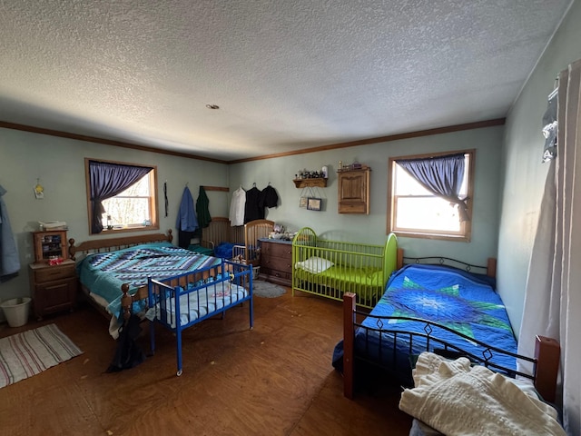 bedroom featuring a textured ceiling, multiple windows, and crown molding