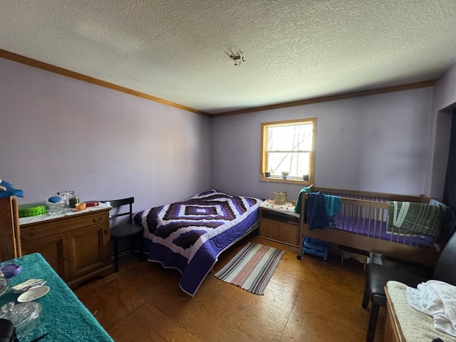 bedroom with a textured ceiling and crown molding
