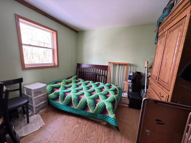 bedroom featuring wood finished floors and a textured ceiling