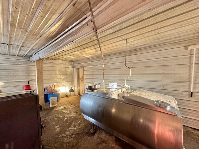 misc room featuring wood walls and concrete flooring