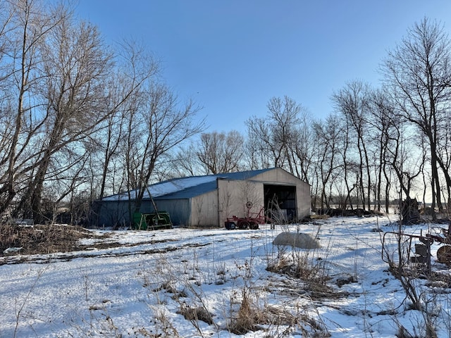 snow covered structure with a pole building and an outdoor structure
