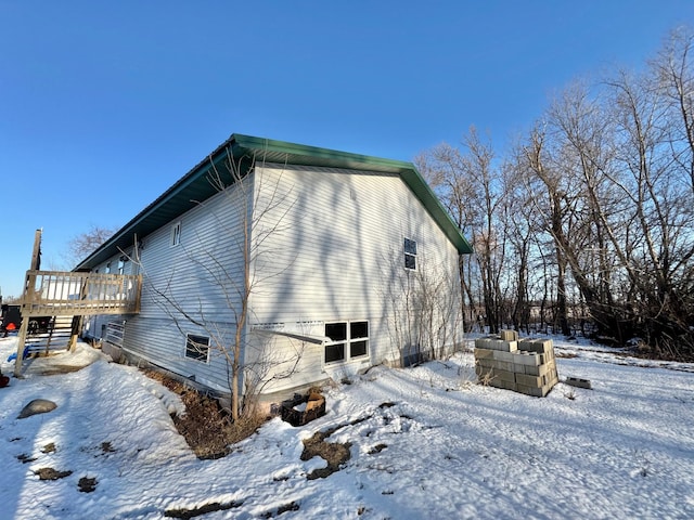 view of snow covered exterior with a wooden deck