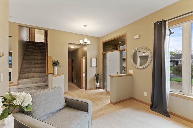 foyer featuring baseboards, an inviting chandelier, stairway, and light wood-type flooring