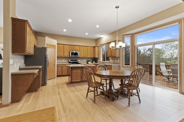 dining room with an inviting chandelier, recessed lighting, and light wood-style floors