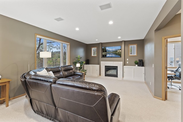 living area with baseboards, recessed lighting, a tiled fireplace, and light carpet