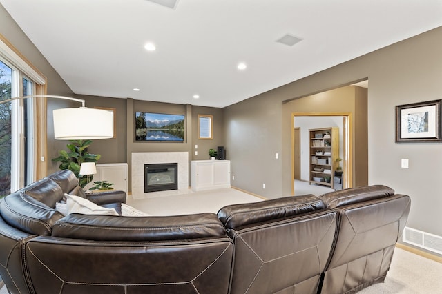living room with baseboards, recessed lighting, a tile fireplace, and visible vents