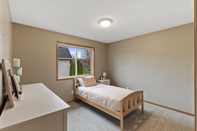 bedroom with baseboards, carpet flooring, and a textured ceiling