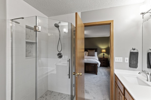 ensuite bathroom with vanity, a textured ceiling, ensuite bath, and a stall shower
