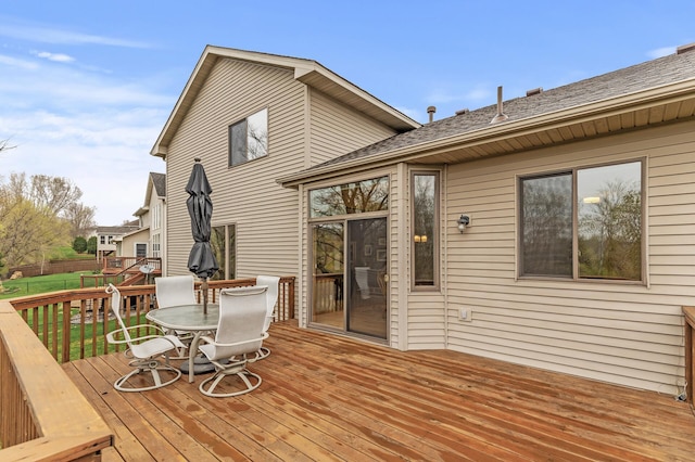 deck with a lawn, fence, and outdoor dining space