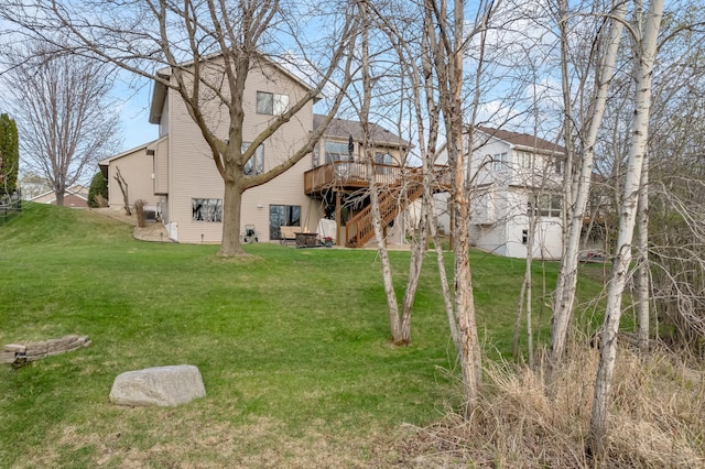 back of property featuring a lawn, a deck, and stairway