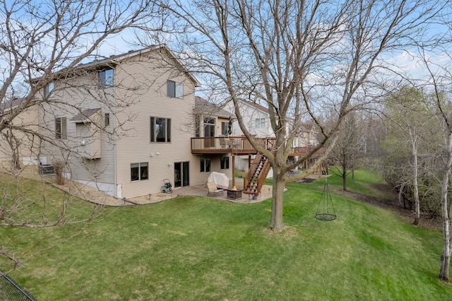 rear view of house featuring a patio, a lawn, a wooden deck, and stairs