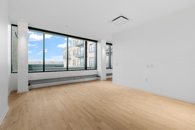 290 Market St Unit 314, Minneapolis, MN 55405 - spare room featuring a baseboard radiator, light wood-style flooring, baseboards, and visible vents