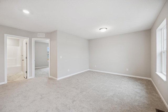empty room featuring baseboards, visible vents, and carpet floors