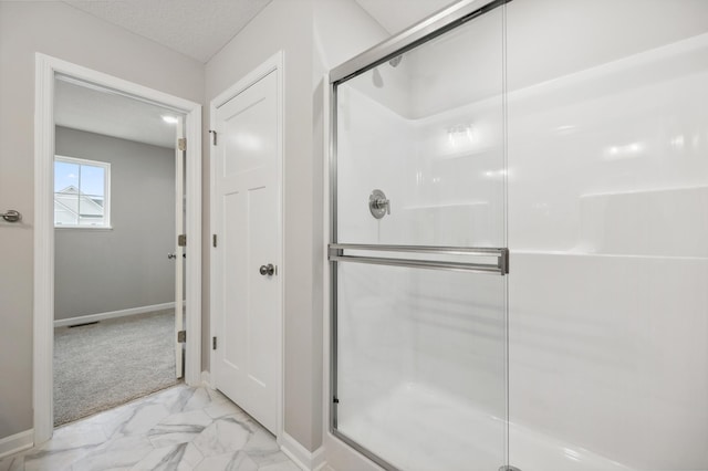bathroom with a shower stall, marble finish floor, and baseboards
