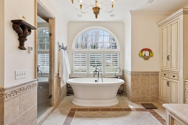 6425 Virginia Dr, Victoria, MN 55331 - full bath with tile walls, a soaking tub, a wainscoted wall, a chandelier, and ornamental molding