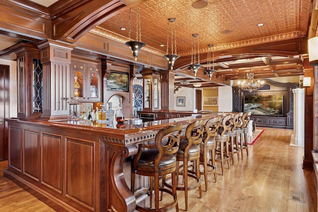 6425 Virginia Dr, Victoria, MN 55331 - indoor wet bar with coffered ceiling, ornamental molding, decorative columns, light wood-type flooring, and a chandelier