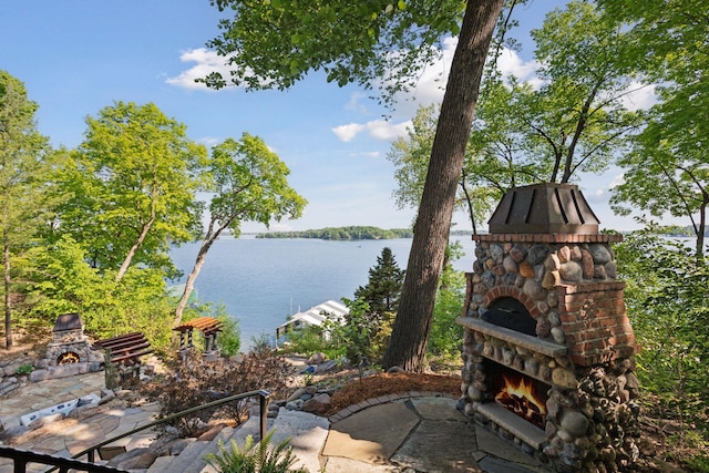6425 Virginia Dr, Victoria, MN 55331 - view of patio / terrace with an outdoor stone fireplace and a water view