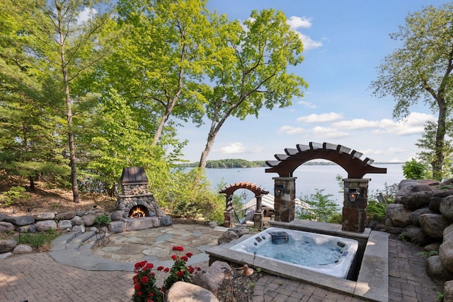 6425 Virginia Dr, Victoria, MN 55331 - view of patio / terrace featuring an outdoor stone fireplace, an outdoor hot tub, and a water view