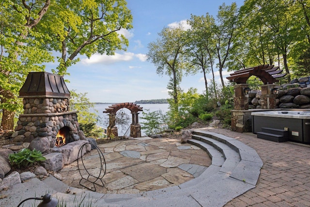 6425 Virginia Dr, Victoria, MN 55331 - view of patio / terrace with a water view and an outdoor stone fireplace