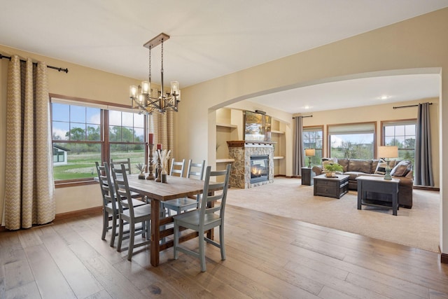 21804 Majestic Dr, Saint Augusta, MN 55320 - dining space with arched walkways, an inviting chandelier, hardwood / wood-style flooring, and a fireplace