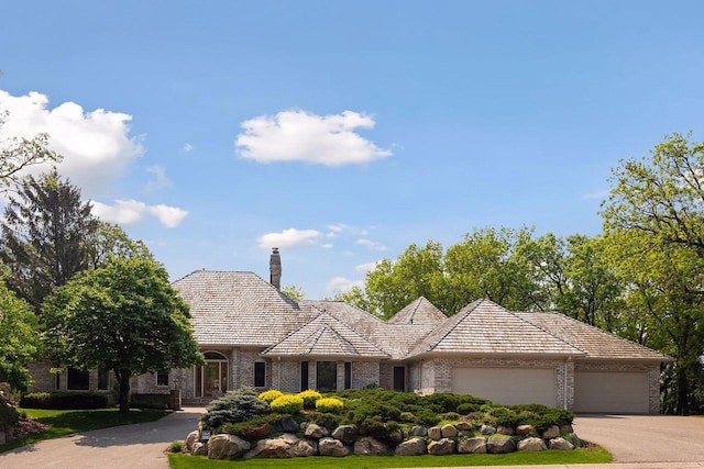 4 Antrim Ter, Edina, MN 55439 - view of front of property featuring concrete driveway, brick siding, a chimney, and an attached garage