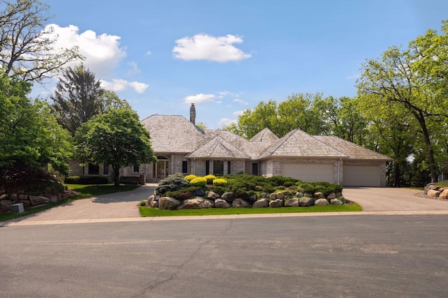 4 Antrim Ter, Edina, MN 55439 - view of front facade featuring concrete driveway, brick siding, a garage, and a chimney