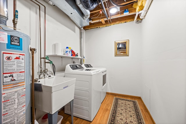 6108 Creek Line Dr, Minnetonka, MN 55345 - clothes washing area featuring water heater, laundry area, light wood-style flooring, washing machine and clothes dryer, and a sink