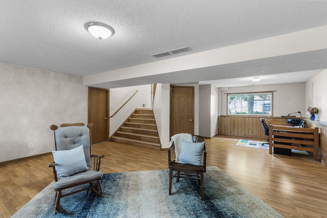 2294 Mathias Rd, Shakopee, MN 55379 - living area featuring wood finished floors, a textured ceiling, stairs, and wainscoting