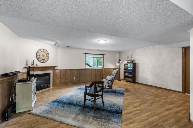 2294 Mathias Rd, Shakopee, MN 55379 - sitting room featuring a textured ceiling, wood finished floors, a glass covered fireplace, and wainscoting