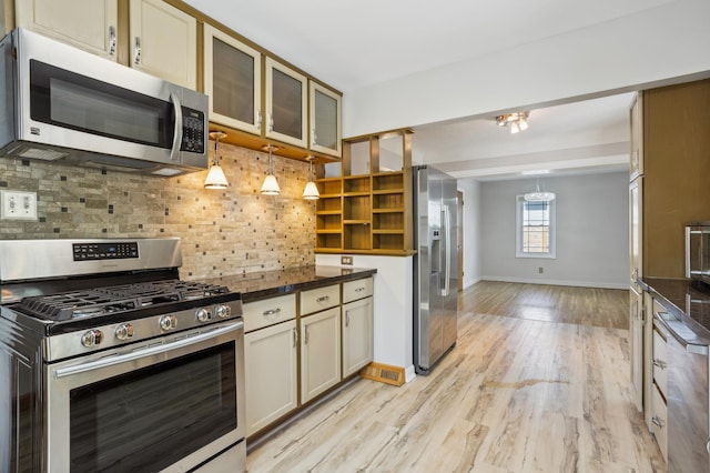3511 Mckinley St NE, Minneapolis, MN 55418 - kitchen with stainless steel appliances, decorative backsplash, glass insert cabinets, light wood-style floors, and baseboards