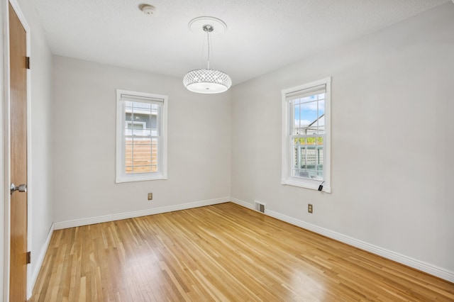 3511 Mckinley St NE, Minneapolis, MN 55418 - spare room featuring plenty of natural light, a smoke detector, light wood finished floors, and baseboards