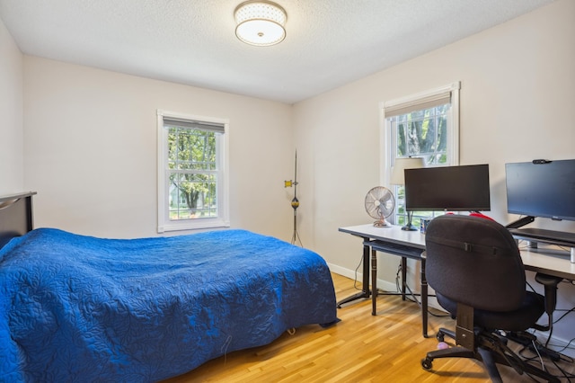 3511 Mckinley St NE, Minneapolis, MN 55418 - bedroom featuring multiple windows, wood finished floors, an office area, and a textured ceiling