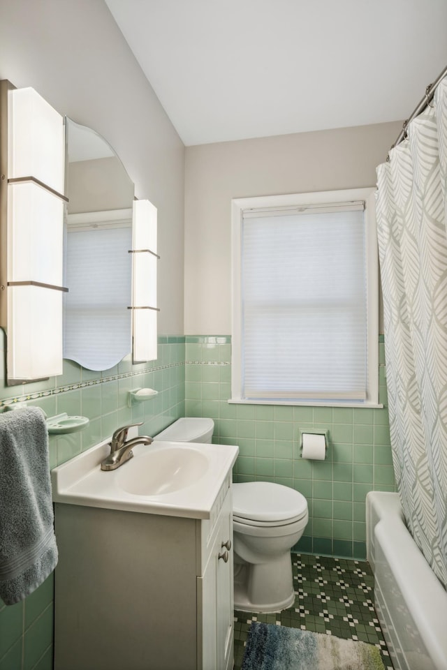 3511 Mckinley St NE, Minneapolis, MN 55418 - full bathroom with tile patterned flooring, toilet, vanity, tile walls, and wainscoting