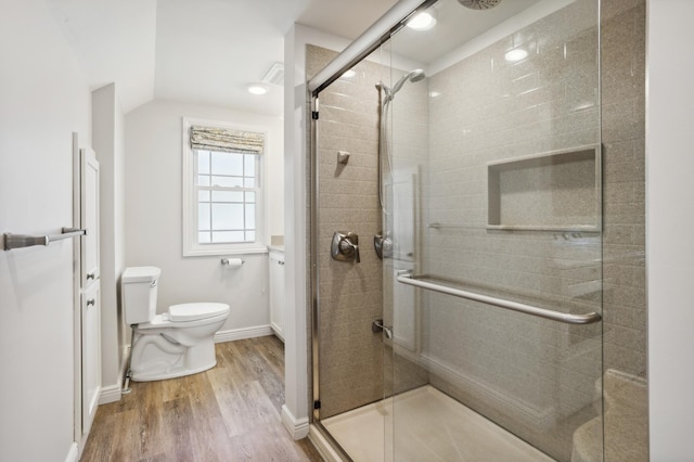 3511 Mckinley St NE, Minneapolis, MN 55418 - bathroom with toilet, wood finished floors, a stall shower, vaulted ceiling, and baseboards