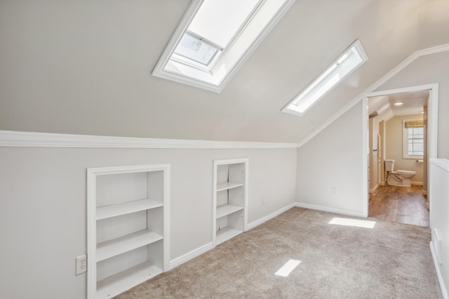 3511 Mckinley St NE, Minneapolis, MN 55418 - additional living space featuring a skylight, built in features, vaulted ceiling, carpet, and baseboards