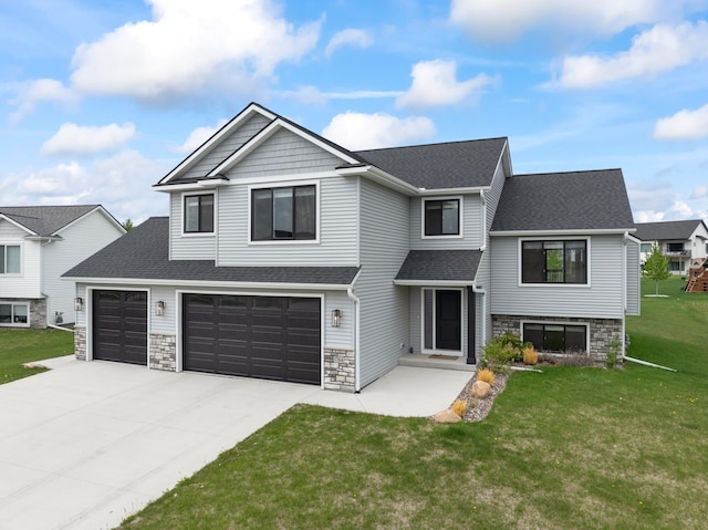 1764 Brandt Dr NE, Byron, MN 55920 - view of front facade featuring stone siding, concrete driveway, a front lawn, a shingled roof, and an attached garage