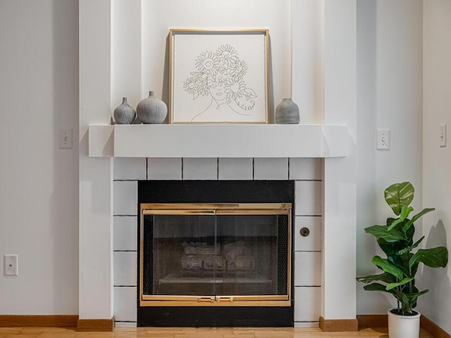 interior details featuring baseboards and a tile fireplace