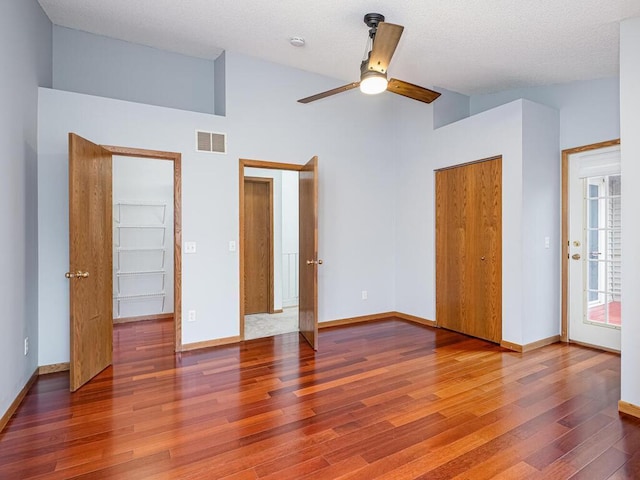 unfurnished bedroom with baseboards, wood finished floors, and visible vents