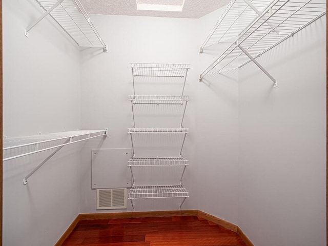 spacious closet with wood finished floors and visible vents
