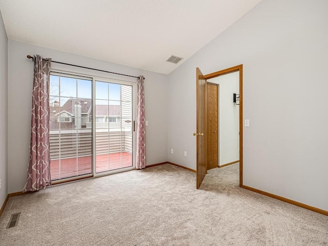 carpeted spare room featuring visible vents, baseboards, and vaulted ceiling
