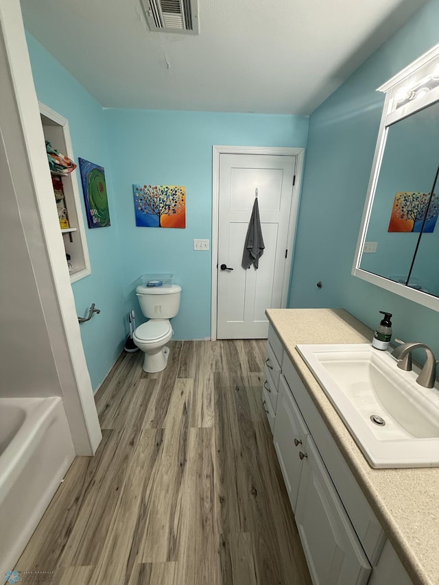 436 2nd Ave E, Halstad, MN 56548 - bathroom with vanity, wood finished floors, toilet, and a tub to relax in