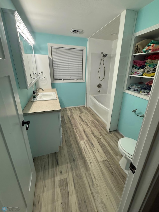 436 2nd Ave E, Halstad, MN 56548 - bathroom featuring vanity, wood finished floors, toilet, and bathing tub / shower combination