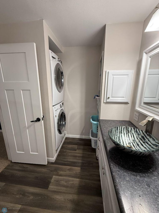 436 2nd Ave E, Halstad, MN 56548 - laundry area featuring stacked washer / drying machine, dark wood-type flooring, and baseboards