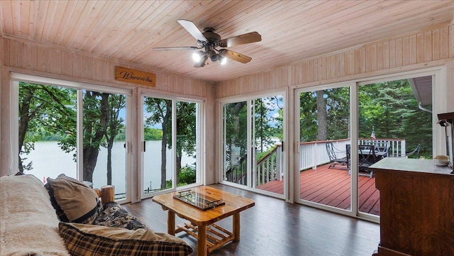 sunroom with wood ceiling, a healthy amount of sunlight, and a deck with water view