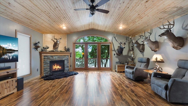 living area with a ceiling fan, wood finished floors, a stone fireplace, wood ceiling, and lofted ceiling